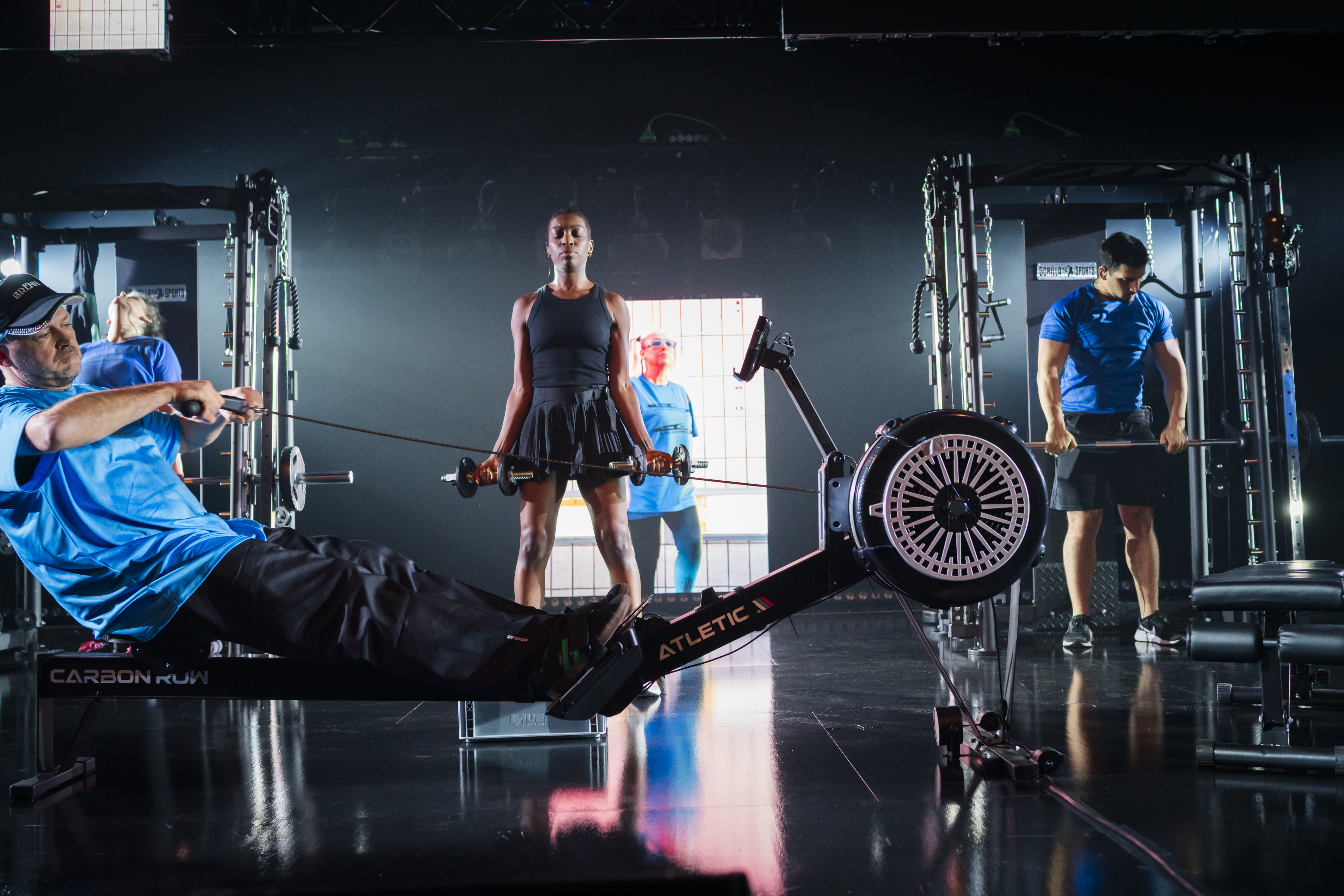 SWEAT. Songs of Push and Pull. Adaption at Pina Bausch Center Wuppertal (November 2025), Daniel Wetzel (Rower), Shar Addams (Dumb Bells), Öz Kaveller (Vocals on Video), Mehmet Ülker (Shrugs) - The Hantelmann Tripple